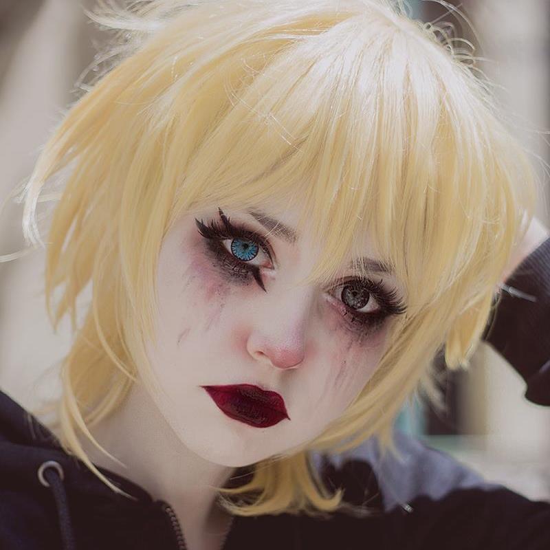 Cosplayer Anzujaamu with short yellow hair and emo-like makeup. She wears lenses, and one eye is blue, while the other is dark-colored.